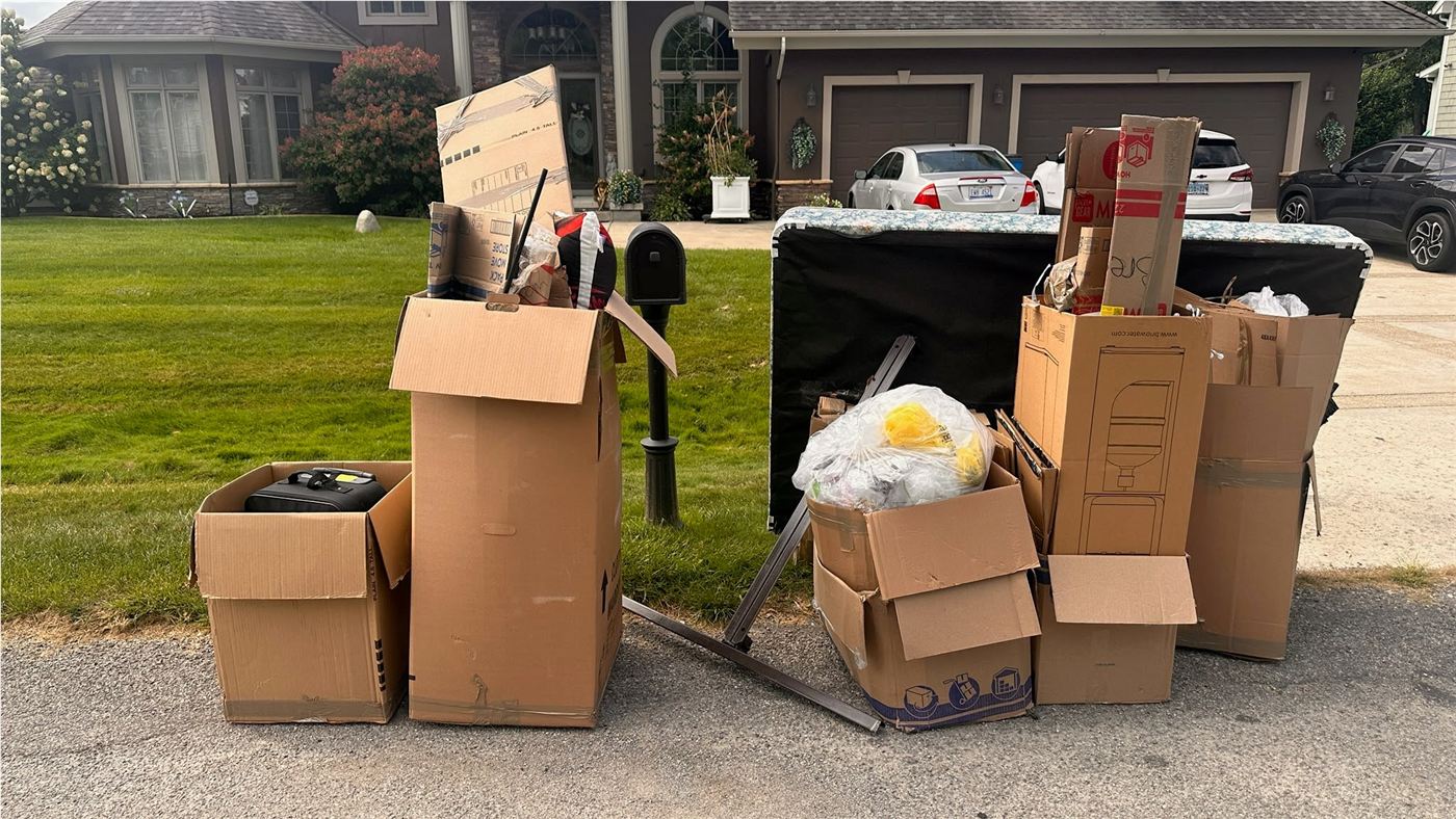 Boxes, a mattress, and household items staged for curbside pickup