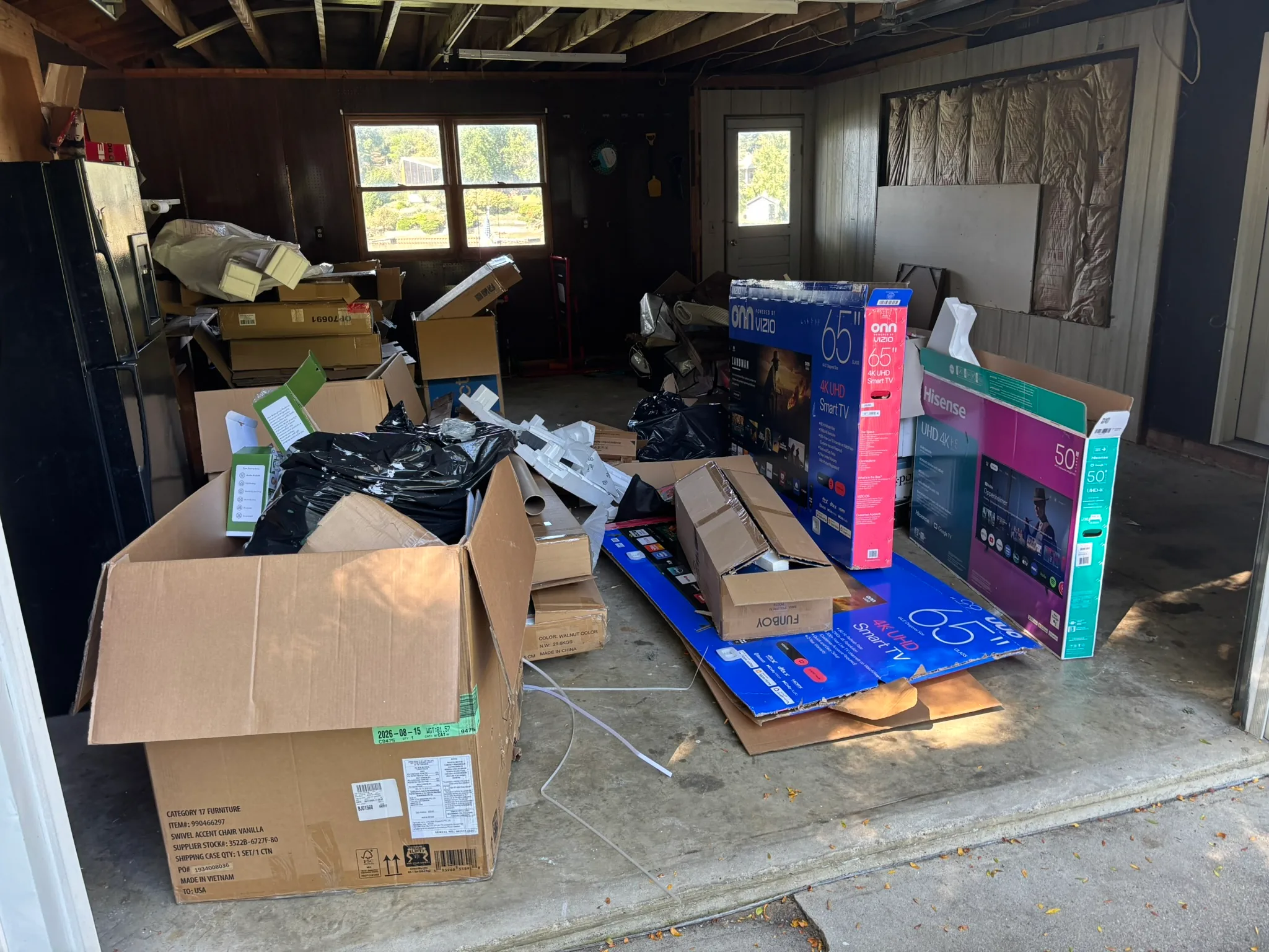 Garage filled with boxes and household items before a Junkernauts Junk Removal cleanout