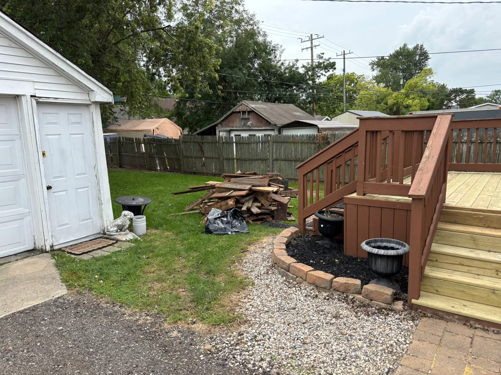 Old deck boards piled beside a deck in Monroe, Michigan, before debris removal